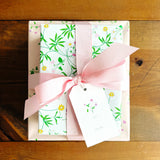 Gift box with floral pattern and pink ribbon on a wooden surface