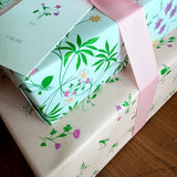 Gift box with floral design and pink ribbon on a wooden surface