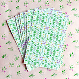 Stack of floral-patterned paper sheets on a matching background